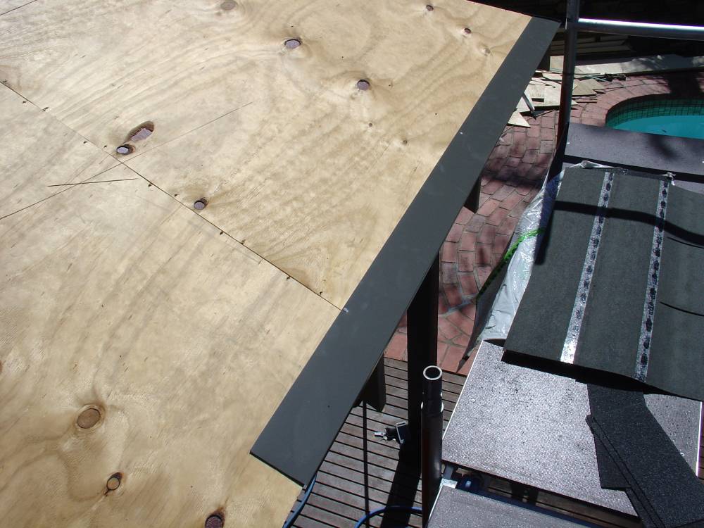 Installing metal drip edge along bottom of plywood roof