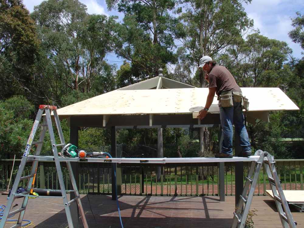 Safe working platform using plank between ladders for roof work
