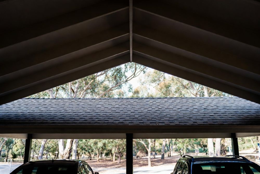 Carport Kits With Premium Shingle Roofs – Beautiful &Amp; Built To Last 11 Interior view under a shingle roof carport showing cool shade and comfort with cars parked inside