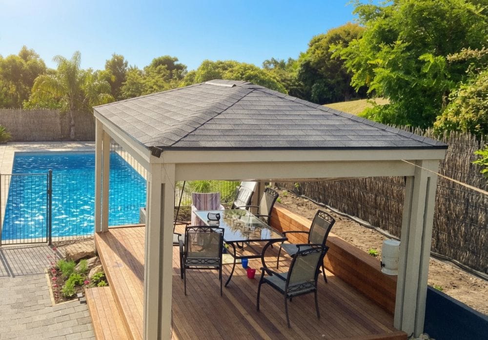 Outdoor Gazebos Australia 26 Custom timber hardtop gazebo kit with 3-tab dual black asphalt shingle roof on a wooden deck with a swimming pool in a beautiful australian backyard